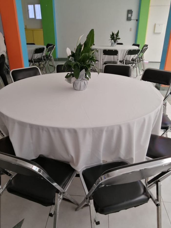 Detalle de mesa redonda con mantel blanco y centro de mesa en Star Fest